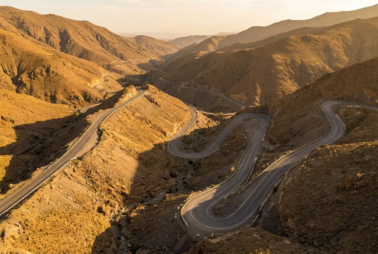 Bochtige bergweg over de Tizi n Tichka in de Hoge Atlas, met uitzicht over droge hellingen