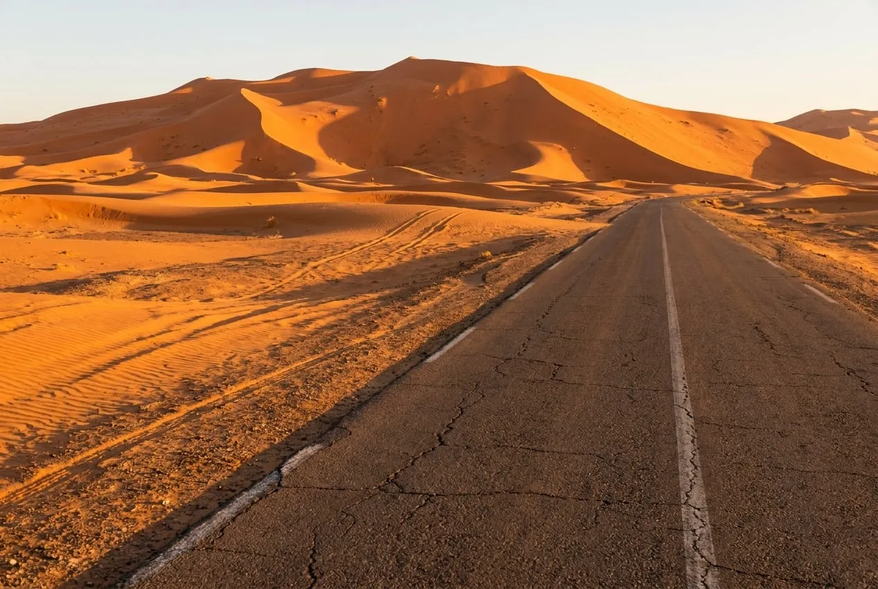 Zandduinen van Erg Chebbi in het late licht, met lange schaduwen over de ribbels